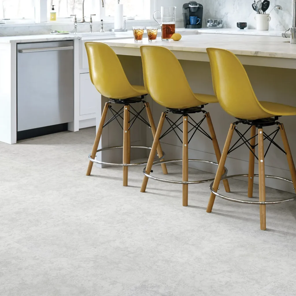 Kitchen island with yellow bar stools on light gray speckled stone-look Shaw Floors Empire tile flooring