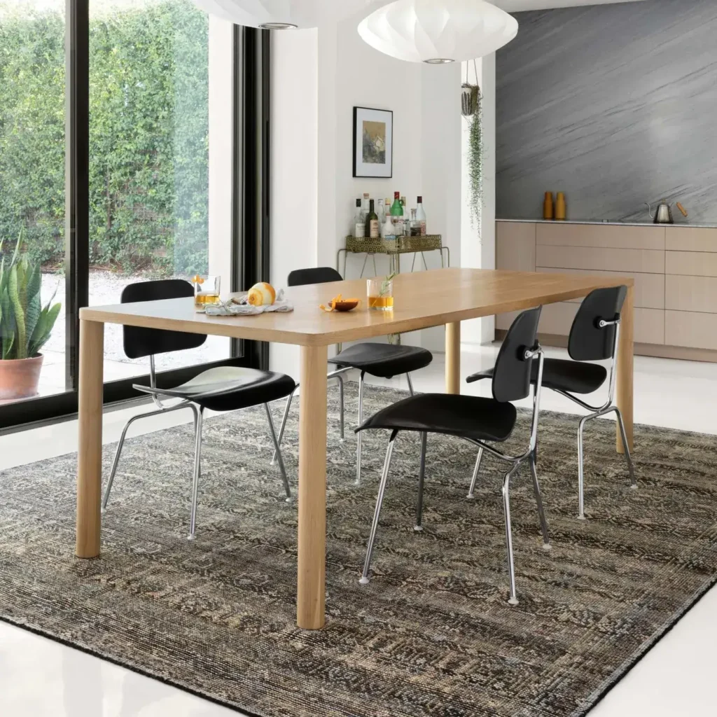 Dining room with wood table and black chairs on a gray and brown distressed Loloi Amara Collection area rug