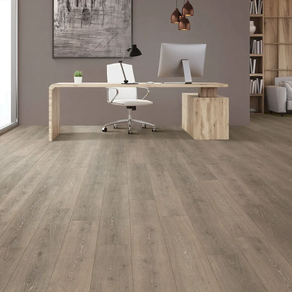 Home office with wood desk and white chair on greige wood-look Mohawk RevWood Select Boardwalk Collective laminate flooring