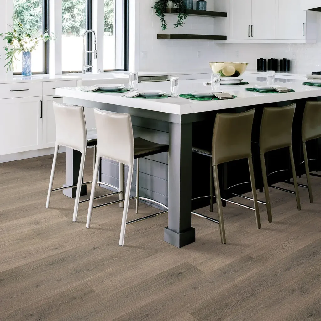 White kitchen island with bar stools on greige wood-look Mohawk RevWood Plus Hampton Villa laminate flooring