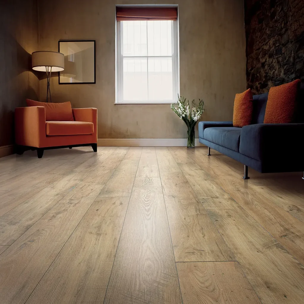 Living room with orange armchair and navy sofa on wide-plank light brown Mohawk RevWood Select Rare Vintage laminate flooring