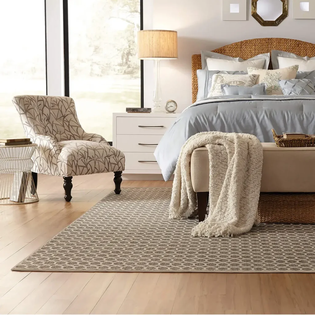 Bedroom with patterned armchair and upholstered bench on a brown geometric Anderson Tuftex Tracery area rug