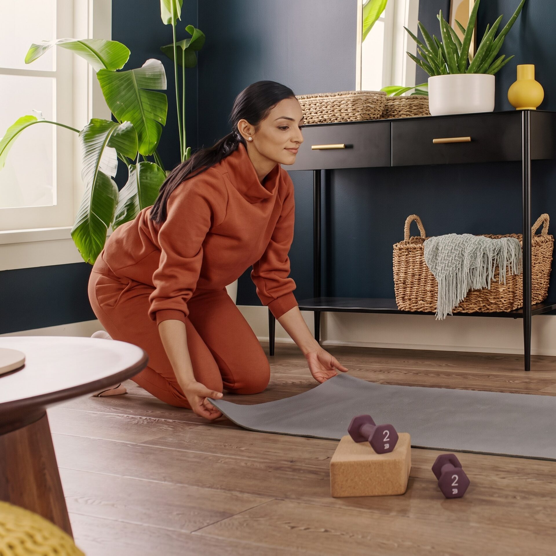 Woman rolling out a yoga mat on comfortable COREtec flooring