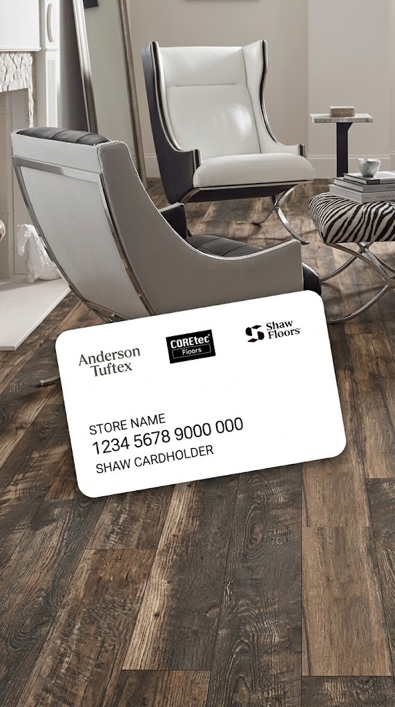 Shaw credit card with Anderson Tuftex, COREtec and Shaw Floors logos on a rustic wood floor in a living room with modern lounge chairs
