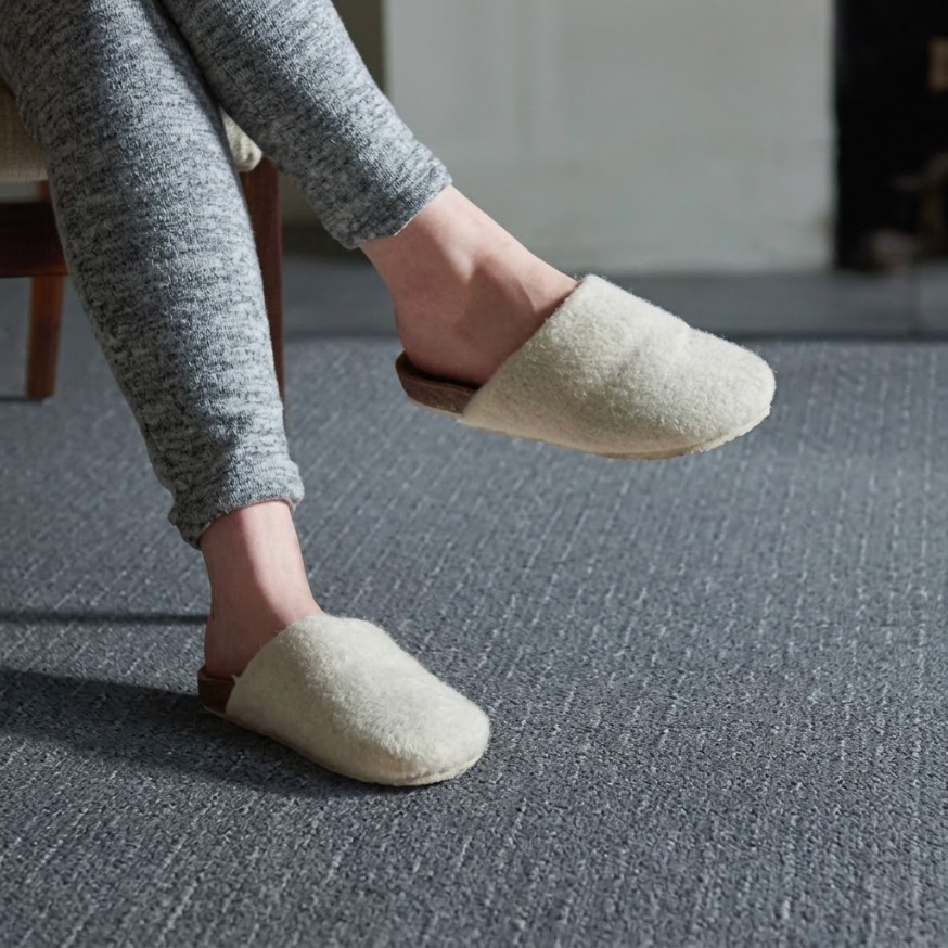 Feet in slippers on cozy grey Shaw carpet