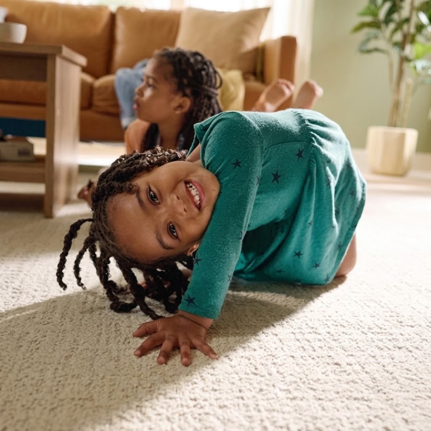 Smiling child playing on soft, durable Shaw carpet